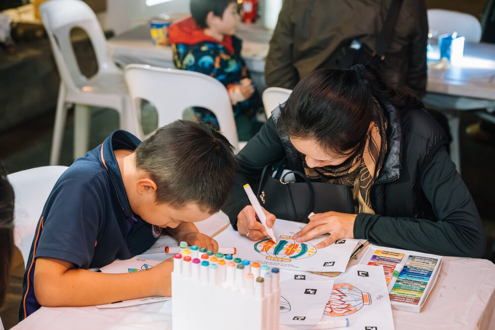 Woman and child colouring Eastwood Stories artwork at Ryde After Dark