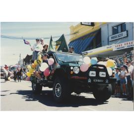 Parade photo showing a group of people on a vechicle