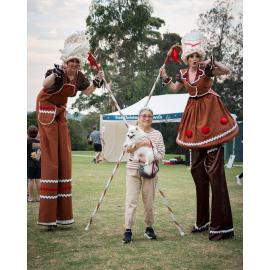 Fur babies welcome at Ryde's 'Cinema in the Park' : stilt walkers pose with owner and dog