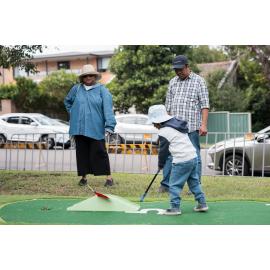 Little boy trying his hand at putt-putt, West Ryde Easter Celebrations